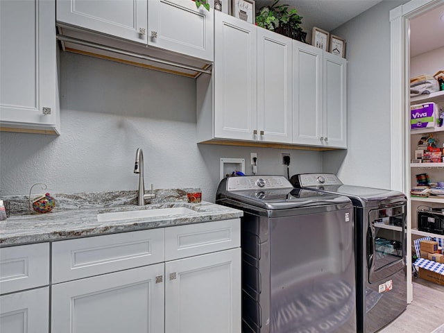 2590 Tarpon Cove Dr Unit 811, Punta Gorda, FL 33950 - laundry area featuring washing machine and dryer, cabinet space, and wood finished floors