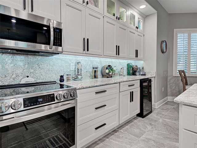 2590 Tarpon Cove Dr Unit 811, Punta Gorda, FL 33950 - kitchen with appliances with stainless steel finishes, wine cooler, light marble finish floors, backsplash, and baseboards