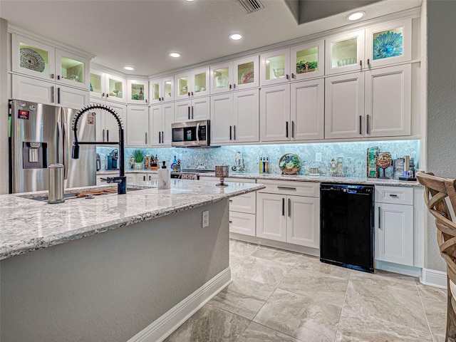 2590 Tarpon Cove Dr Unit 811, Punta Gorda, FL 33950 - kitchen with stainless steel appliances, white cabinetry, decorative backsplash, light stone countertops, and recessed lighting