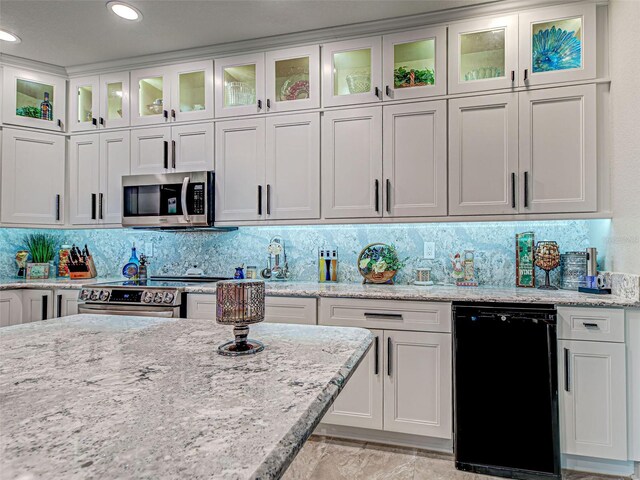 2590 Tarpon Cove Dr Unit 811, Punta Gorda, FL 33950 - kitchen with appliances with stainless steel finishes, white cabinetry, decorative backsplash, light stone countertops, and recessed lighting