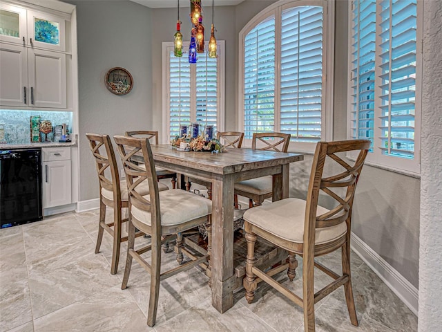 2590 Tarpon Cove Dr Unit 811, Punta Gorda, FL 33950 - dining space featuring plenty of natural light, baseboards, a bar, beverage cooler, and a textured wall