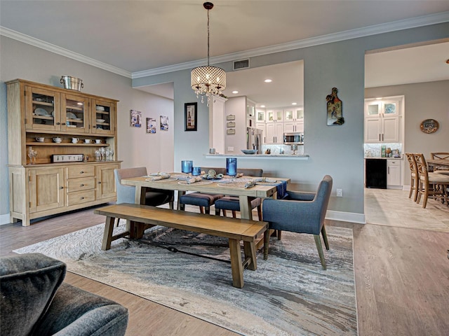 2590 Tarpon Cove Dr Unit 811, Punta Gorda, FL 33950 - dining space featuring a chandelier, light wood-type flooring, ornamental molding, and baseboards