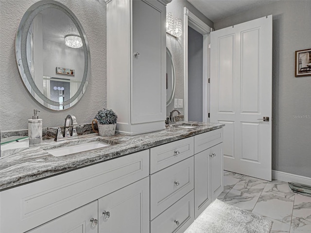 2590 Tarpon Cove Dr Unit 811, Punta Gorda, FL 33950 - full bathroom featuring marble look tiles, double vanity, baseboards, and a textured wall