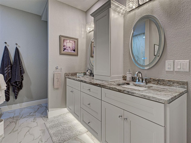 2590 Tarpon Cove Dr Unit 811, Punta Gorda, FL 33950 - bathroom featuring marble finish flooring, double vanity, a textured wall, and baseboards
