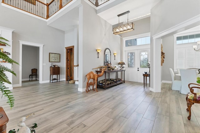 565 Green Dolphin Dr S, Placida, FL 33946 - entrance foyer featuring a towering ceiling, a chandelier, light wood-style floors, and baseboards