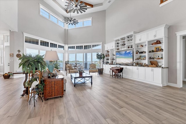565 Green Dolphin Dr S, Placida, FL 33946 - living room with a towering ceiling, light wood-style floors, ceiling fan, and baseboards
