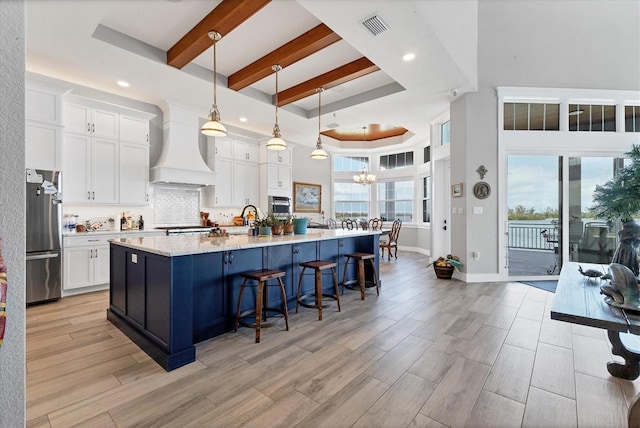 565 Green Dolphin Dr S, Placida, FL 33946 - kitchen featuring custom range hood, stainless steel appliances, white cabinetry, recessed lighting, and beamed ceiling