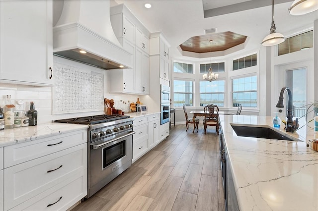 565 Green Dolphin Dr S, Placida, FL 33946 - kitchen featuring custom range hood, stainless steel appliances, a sink, a chandelier, and white cabinetry