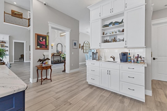 565 Green Dolphin Dr S, Placida, FL 33946 - kitchen featuring tasteful backsplash, white cabinetry, open shelves, a sink, and baseboards