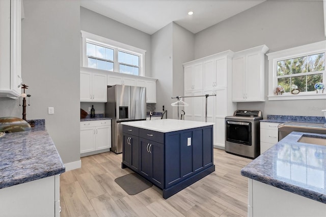 565 Green Dolphin Dr S, Placida, FL 33946 - kitchen with washer / clothes dryer, stainless steel fridge, white cabinetry, healthy amount of natural light, and recessed lighting