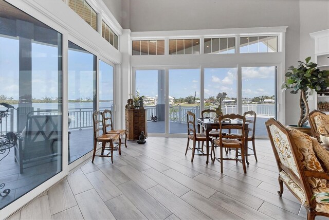 565 Green Dolphin Dr S, Placida, FL 33946 - dining room featuring a water view, a high ceiling, and light wood-style floors