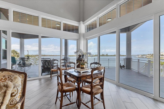 565 Green Dolphin Dr S, Placida, FL 33946 - dining area featuring a water view, a high ceiling, and light wood-style flooring
