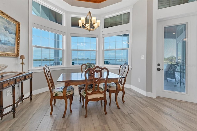 565 Green Dolphin Dr S, Placida, FL 33946 - dining space with a chandelier, light wood-type flooring, baseboards, and a water view