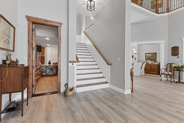 565 Green Dolphin Dr S, Placida, FL 33946 - staircase featuring a towering ceiling, wood finished floors, baseboards, and a chandelier
