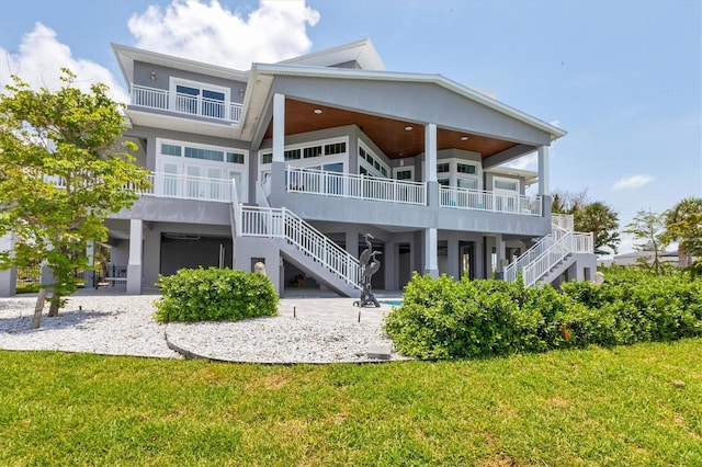 565 Green Dolphin Dr S, Placida, FL 33946 - back of house with stairs, a lawn, and stucco siding