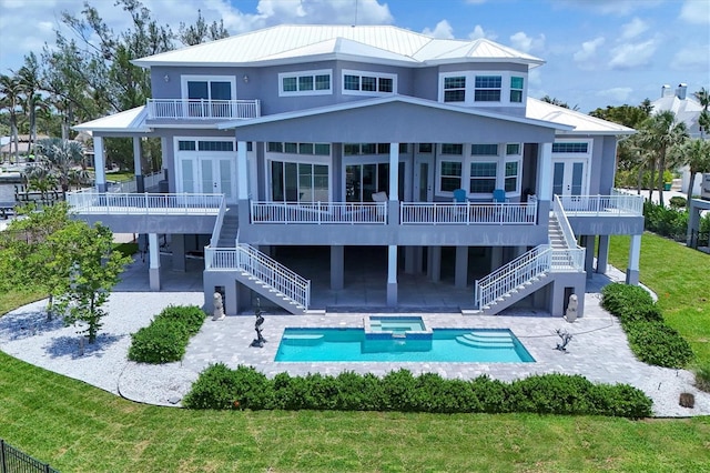 565 Green Dolphin Dr S, Placida, FL 33946 - rear view of house featuring stairway, french doors, a balcony, and a pool with connected hot tub