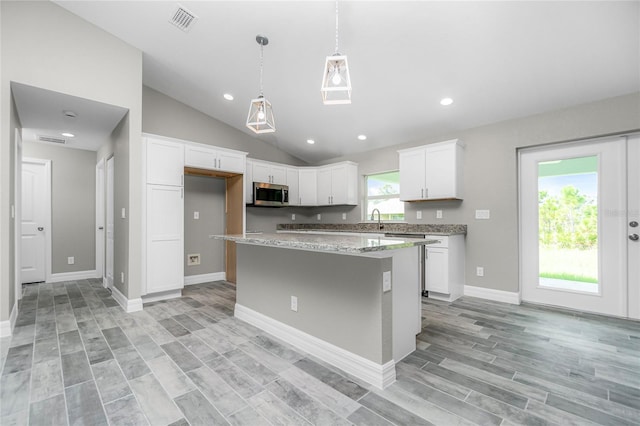 8270 Cook Ct, Port Charlotte, FL 33981 - kitchen featuring stainless steel appliances, a sink, white cabinets, a kitchen island, and pendant lighting