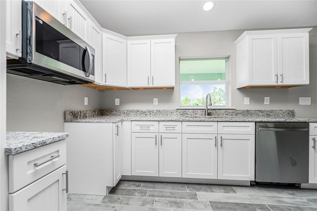 8270 Cook Ct, Port Charlotte, FL 33981 - kitchen featuring appliances with stainless steel finishes, a sink, light stone counters, recessed lighting, and white cabinetry