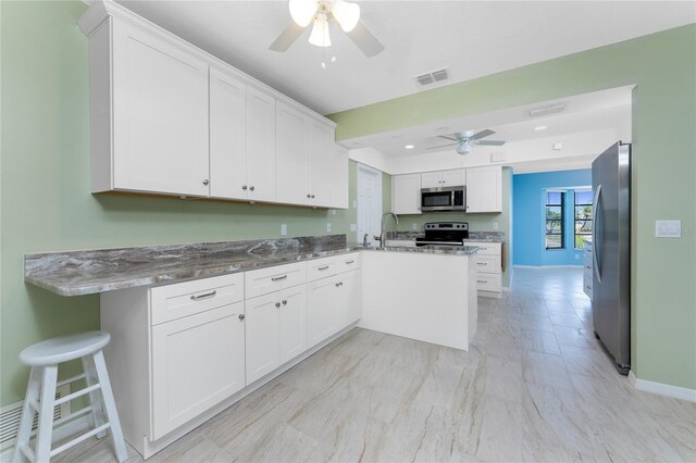 23 Bunker Cir, Rotonda West, FL 33947 - kitchen featuring appliances with stainless steel finishes, a ceiling fan, a peninsula, white cabinetry, and recessed lighting