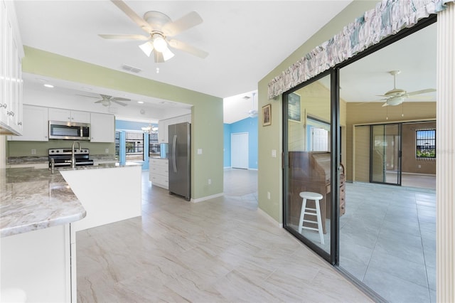 23 Bunker Cir, Rotonda West, FL 33947 - kitchen featuring stainless steel appliances, a ceiling fan, white cabinetry, and light stone counters
