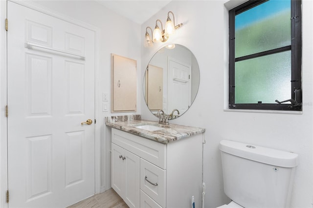 23 Bunker Cir, Rotonda West, FL 33947 - bathroom with vanity, toilet, and wood finished floors