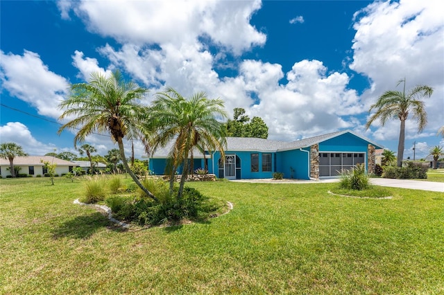 23 Bunker Cir, Rotonda West, FL 33947 - ranch-style house featuring an attached garage, driveway, a front yard, and stone siding