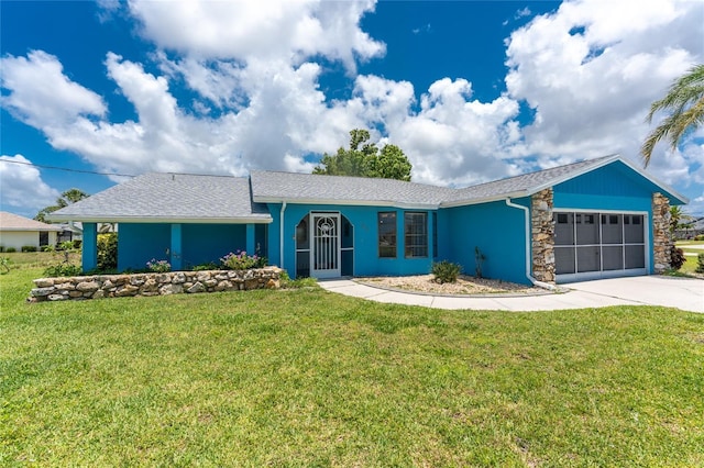 23 Bunker Cir, Rotonda West, FL 33947 - view of front of home with a garage, a front lawn, concrete driveway, and stone siding
