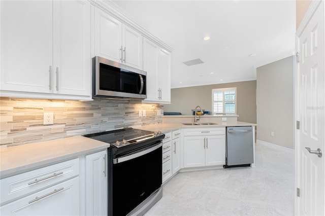 13859 Vadini St, Venice, FL 34293 - kitchen with appliances with stainless steel finishes, a sink, backsplash, a peninsula, and light countertops