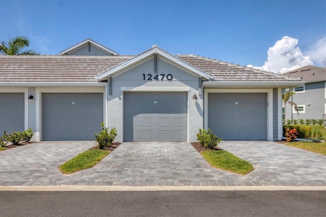 12470 Wellen Golf St Unit 108, Venice, FL 34293 - view of property featuring stucco siding, community garages, and a tiled roof