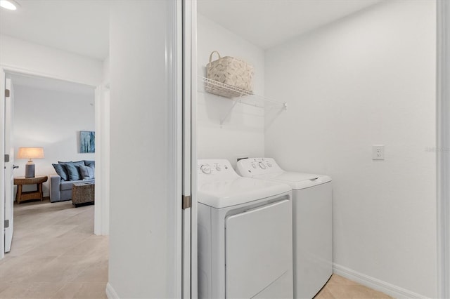 12470 Wellen Golf St Unit 108, Venice, FL 34293 - laundry room featuring washer and dryer, light tile patterned floors, and baseboards