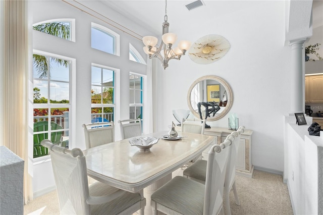 116 Tournament Rd, Rotonda West, FL 33947 - dining room with a chandelier, light colored carpet, decorative columns, and baseboards