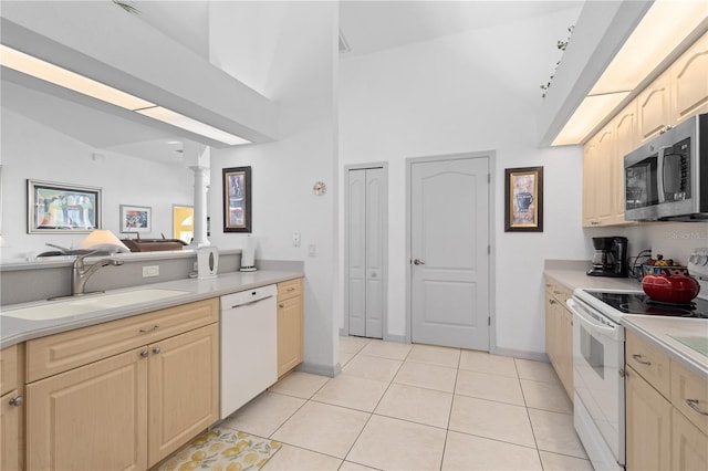 116 Tournament Rd, Rotonda West, FL 33947 - kitchen with white appliances, a sink, light countertops, decorative columns, and light tile patterned floors