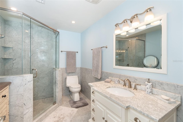 180 N Gulf Blvd Unit 5, Placida, FL 33946 - bathroom featuring vanity, toilet, a shower stall, tile walls, and wainscoting