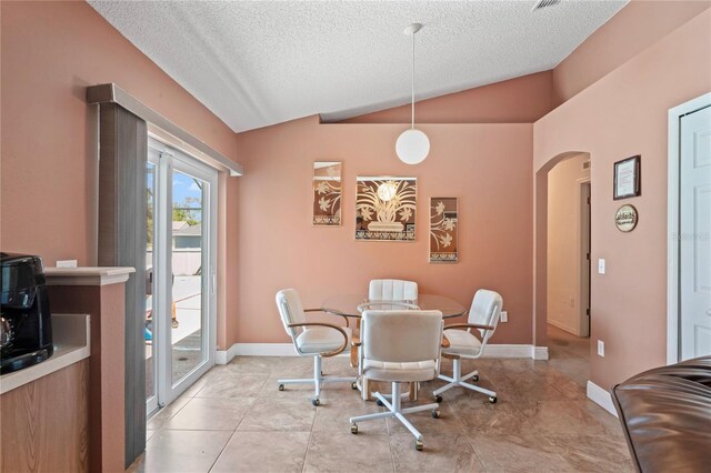 5510 Moongate Rd, Spring Hill, FL 34606 - dining area featuring vaulted ceiling, arched walkways, a textured ceiling, baseboards, and light tile patterned flooring