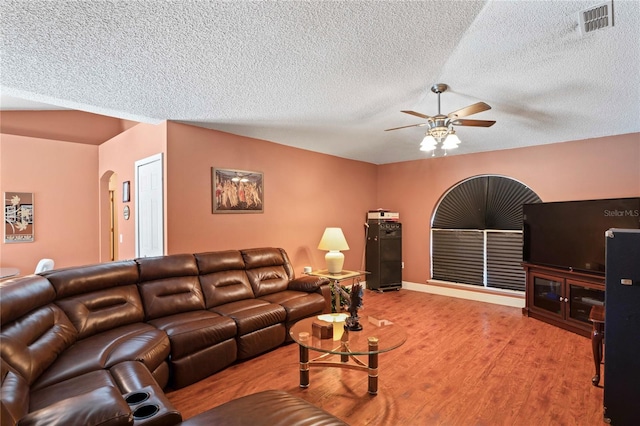 5510 Moongate Rd, Spring Hill, FL 34606 - living room with a ceiling fan, a textured ceiling, arched walkways, and wood finished floors