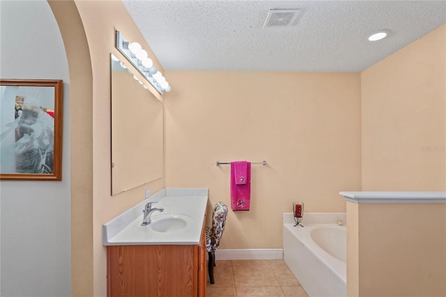 5510 Moongate Rd, Spring Hill, FL 34606 - bathroom featuring tile patterned floors, a textured ceiling, vanity, a bath, and baseboards