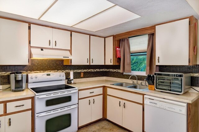 3261 Rogue St, North Port, FL 34291 - kitchen with white appliances, under cabinet range hood, a sink, light countertops, and decorative backsplash