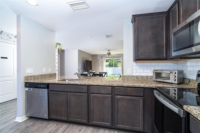 2408 Bonanza Ln, North Port, FL 34286 - kitchen featuring appliances with stainless steel finishes, dark brown cabinets, a sink, light wood-type flooring, and a ceiling fan