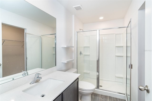 2408 Bonanza Ln, North Port, FL 34286 - bathroom with toilet, a stall shower, vanity, wood finished floors, and a spacious closet