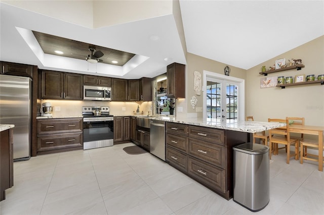 209 Fairway Rd, Rotonda West, FL 33947 - kitchen with stainless steel appliances, a peninsula, ceiling fan, dark brown cabinets, and light stone counters