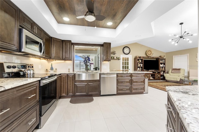 209 Fairway Rd, Rotonda West, FL 33947 - kitchen featuring appliances with stainless steel finishes, a sink, a tray ceiling, dark brown cabinets, and open floor plan