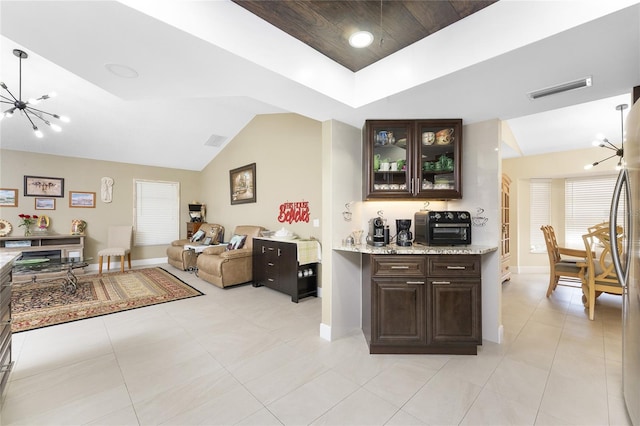 209 Fairway Rd, Rotonda West, FL 33947 - bar featuring a chandelier, baseboards, light tile patterned flooring, vaulted ceiling, and a tray ceiling
