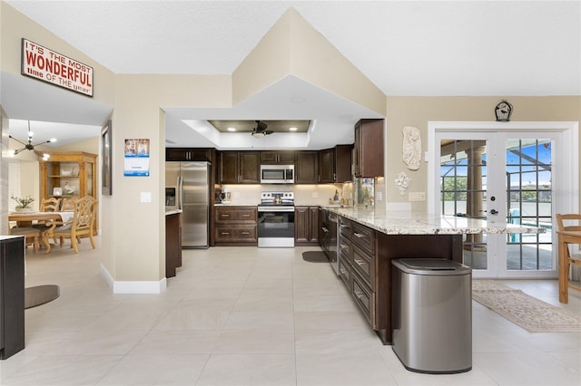 209 Fairway Rd, Rotonda West, FL 33947 - kitchen featuring appliances with stainless steel finishes, dark brown cabinets, ceiling fan, french doors, and light stone countertops