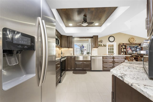 209 Fairway Rd, Rotonda West, FL 33947 - kitchen featuring appliances with stainless steel finishes, a tray ceiling, ceiling fan, a sink, and light tile patterned flooring