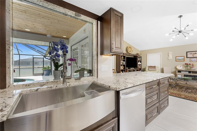 209 Fairway Rd, Rotonda West, FL 33947 - kitchen with dishwashing machine, a sink, light tile patterned floors, vaulted ceiling, and light stone counters