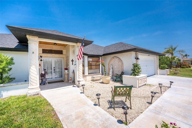 209 Fairway Rd, Rotonda West, FL 33947 - view of front of home featuring french doors, an attached garage, concrete driveway, roof with shingles, and stucco siding