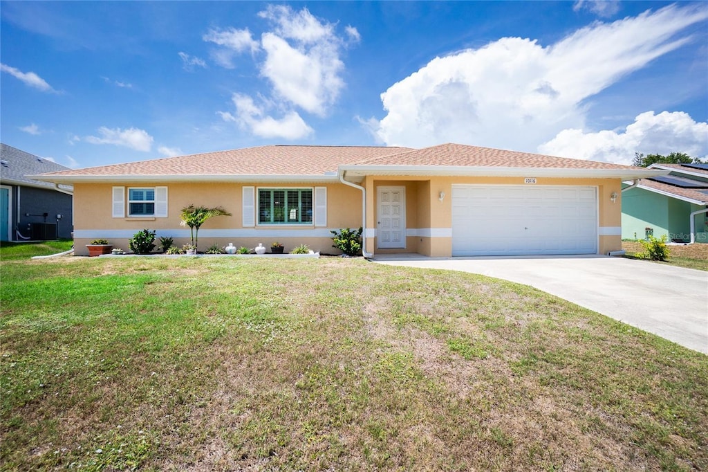 10116 Melanie Ave, Englewood, FL 34224 - ranch-style home with stucco siding, a garage, concrete driveway, a front lawn, and central air condition unit