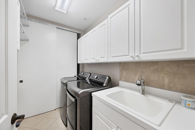 11100 Hacienda Del Mar Blvd Unit G-304, Placida, FL 33946 - laundry room featuring washer and dryer, cabinet space, and light tile patterned floors
