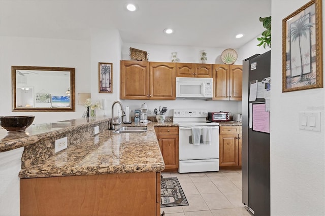 8411 Placida Rd Unit 404, Placida, FL 33946 - kitchen featuring white appliances, a sink, brown cabinets, light tile patterned flooring, and light stone counters