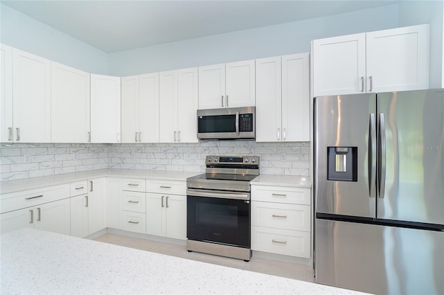 398 Sunset Rd N, Rotonda West, FL 33947 - kitchen with stainless steel appliances, decorative backsplash, and white cabinets